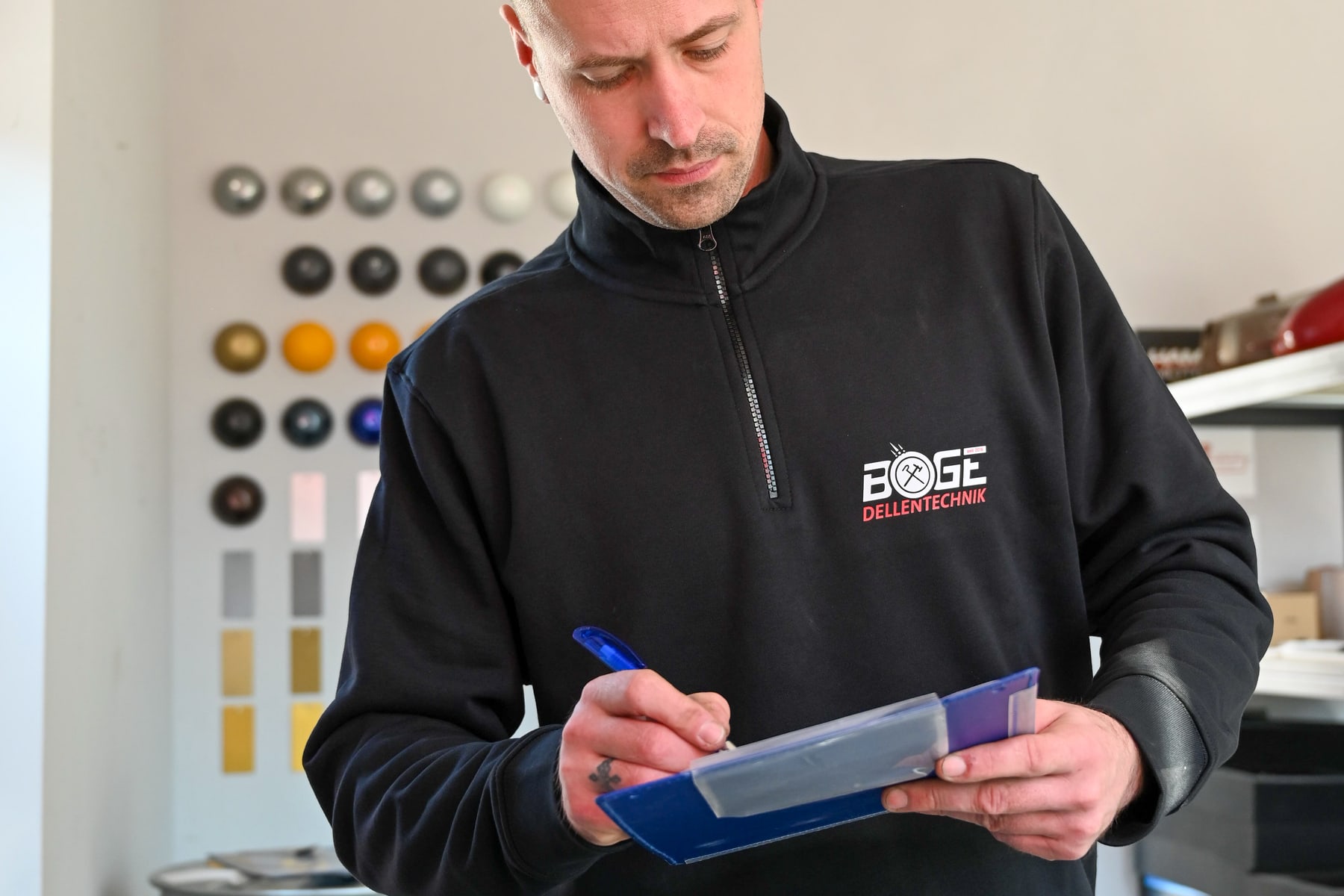 Sebastian Boge dokumentiert konzentriert die Prüfung eines Kundenauftrags.