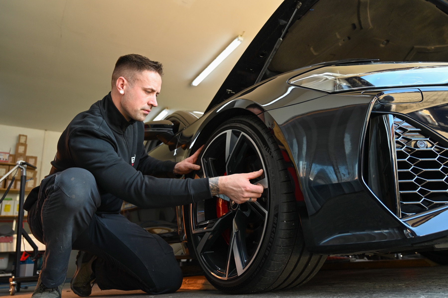 Sebastian Boge kontrolliert eine hochwertige Leichtmetallfelge am Fahrzeug.