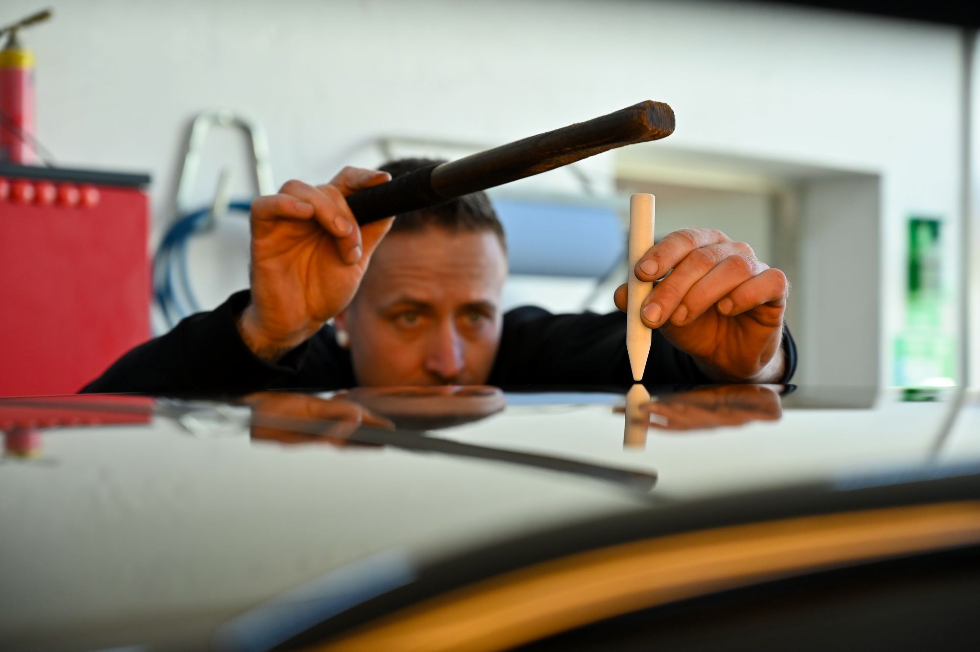 Sebastian Boge kontrolliert eine von Hageldellen betroffene Fahrzeugoberfläche.